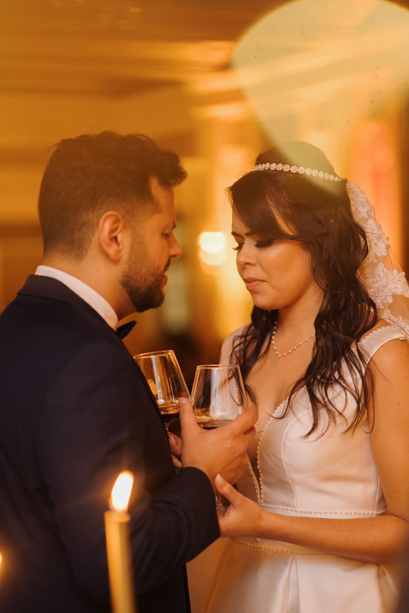 Bride and groom sharing a toast with wine glasses at their reception