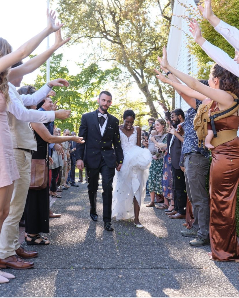 Bride and groom walking through a cheering crowd of friends and family